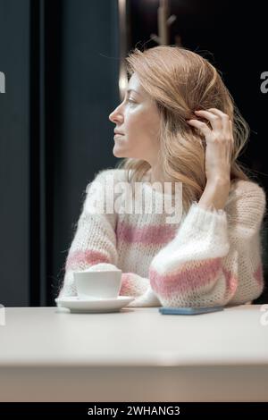 Woman waiting at the table with cup of coffee Stock Photo