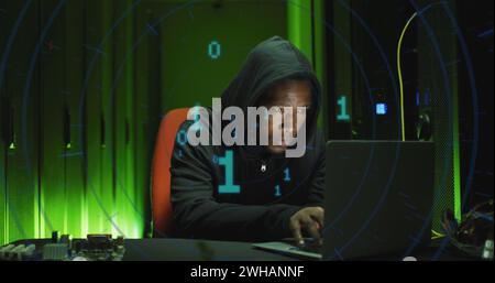 Image of binary coding over african american male hacker with computer and computer servers Stock Photo