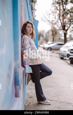 Woman in casual clothes near the wall on the street Stock Photo
