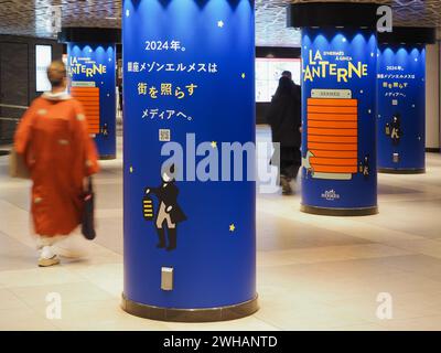 TOKYO, JAPAN - February 7, 2024: Subterranean concourse in Ginza with adverts for a Maison Hermes Ginza's La Lanterne proejct in Tokyo on columns. Stock Photo