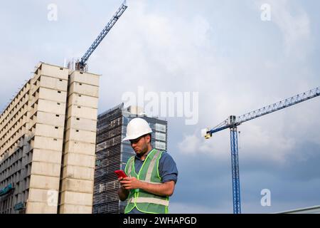 Engineer man working on his phone in construction site Stock Photo