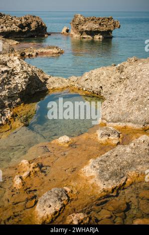 Tide pools of sea water along the rocky shore of the island of Crete Stock Photo