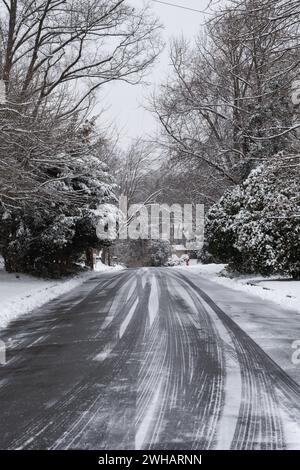 Snow-covered street in suburban neighborhood on a gray winter day. Stock Photo
