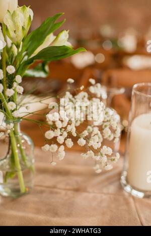 Close up of baby's breath flowers in a glass vase on wood table Stock Photo