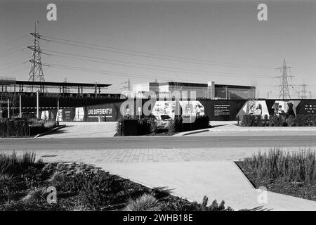 Construction site hoardings and pylons near Barking Riverside Station, Greater London UK, in monochrome Stock Photo