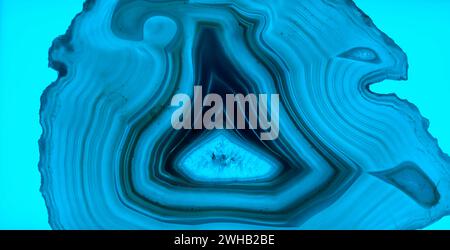 Backlit thin slice of blue Agate with crystals in a geode, lit from behind Stock Photo