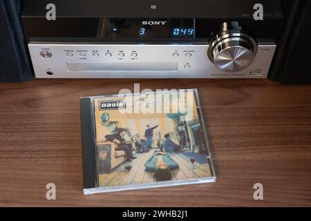 Definitely Maybe was originally released in August 1994 by Oasis. It was the fastest selling debut album ever (at the time). CD in front of CD player Stock Photo