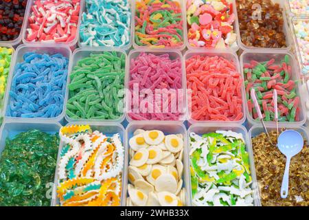 Colorful array of assorted gummy candies presented in containers, offering a variety of shapes and flavors for a sweet treat experience Stock Photo