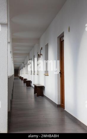 Rows of wooden benches line the hallway Stock Photo