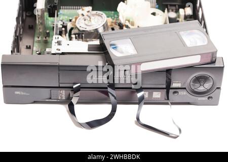 Retro disassembled video cassette recorder with broken VHS cassette with unwound tape isolated on white background Stock Photo