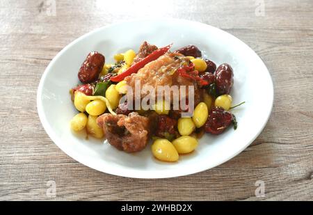 deep fried slice mango fish with yellow ginkgo and pickled jujube couple black mushroom in sweet sour sauce on plate Stock Photo