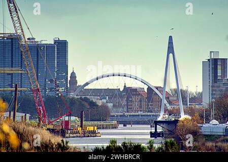 Glasgow, Scotland, UK. 9tht February, 2024.  he Govan-Partick Bridge project includes the construction of a new pedestrian/cycle bridge over the River Clyde Cloudy riverside and Dancing wave the longest mural in the city celebrates the heritage of the river clyde and runs along its bank illustrating its sites and history where the new bridge to govan is being built beside the museum and the clipper ship glenlee whilst the navy newest warship hms glasgow is being built on the other bank by bae systems. Credit Gerard Ferry/Alamy Live News Stock Photo