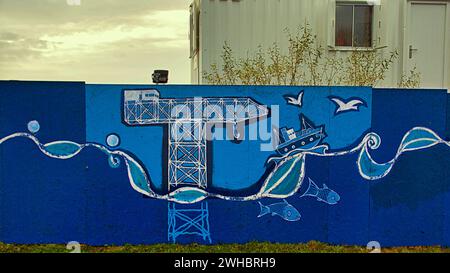 Glasgow, Scotland, UK. 9tht February, 2024.  Cloudy riverside and Dancing wave the longest mural in the city celebrates the heritage of the river clyde and runs along its bank illustrating its sites and history where the clyde titan ship building crane is illustrated. Credit Gerard Ferry/Alamy Live News Stock Photo