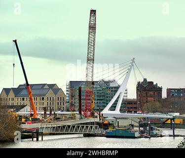 Glasgow, Scotland, UK. 9tht February, 2024.  he Govan-Partick Bridge project includes the construction of a new pedestrian/cycle bridge over the River Clyde Cloudy riverside and Dancing wave the longest mural in the city celebrates the heritage of the river clyde and runs along its bank illustrating its sites and history where the new bridge to govan is being built beside the museum and the clipper ship glenlee whilst the navy newest warship hms glasgow is being built on the other bank by bae systems. Credit Gerard Ferry/Alamy Live News Stock Photo