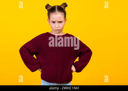 Photo of disappointed unsatisfied girl put hands waist sullen face empty space isolated on yellow color background Stock Photo