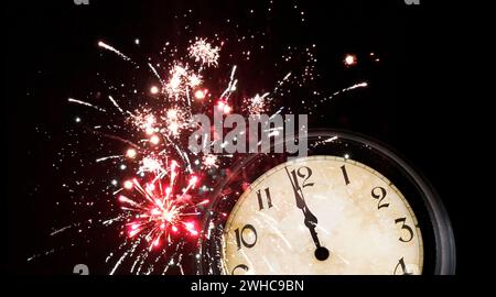Clock face at twelve midnight before fireworks on New Year's Eve Stock Photo