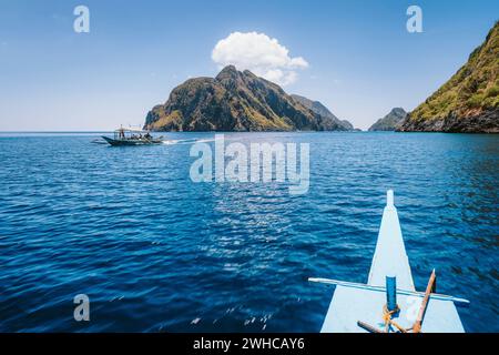 El Nido, Philippines. Front of Island hopping Tour boat hover over open strait between exotic karst limestone islands on travel tour trip. Stock Photo