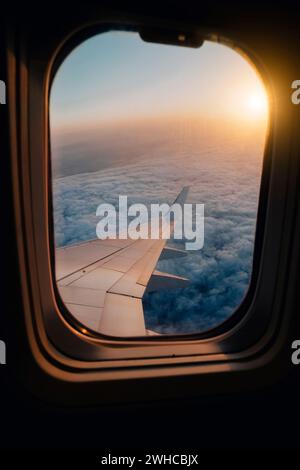 Evening airplane flight in twilight sky. Sunset view in cabin frozen window frame. Stock Photo