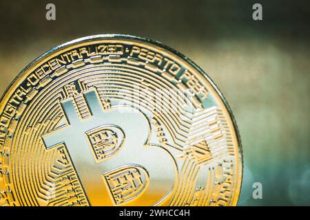 Golden Bitcoin on a luminous background. Close up. Stock Photo