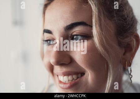 Cropped close up part of female face, happy young Caucasian woman portrait look aside, having white-toothed smile, wrinkles around eyes, staring into distance. Natural beauty, skincare treatments ad Stock Photo