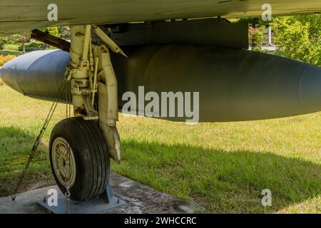 Closeup of starboard landing gear and external fuel tank on military fighter jet on display in public park Stock Photo