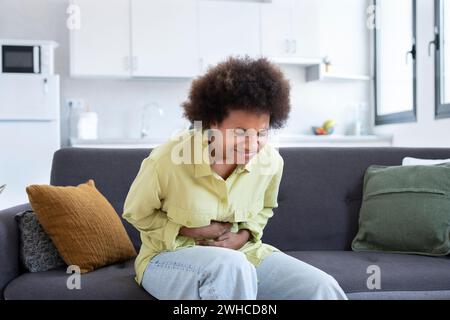 Sick young woman in pain holding belly stomach feeling hurt abdomen ache gastritis pancreatitis symptoms or diarrhea, upset teen girl suffering from indigestion flatulence abdominal problem concept Stock Photo