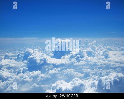 Aerial view on white fluffy clouds. flight over the clouds. view of the clouds from the airplane window. Nature view soft white clouds on pastel blue Stock Photo