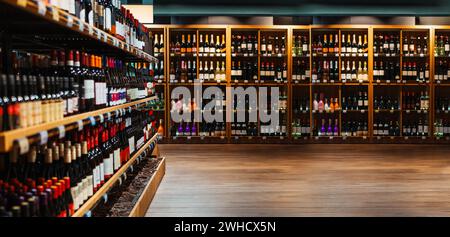 Composite image of liquor store. Wine and champaign bottles on shelves in liquor store. Stock Photo