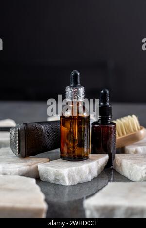 Man beard grooming items on a stone table surface, comb, oil and electric trimmer Stock Photo
