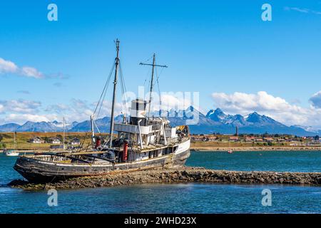 Wreck of a cutter against the backdrop of the mountains in the harbour of Ushuaia, Tierra del Fuego Island, Patagonia, Argentina Stock Photo