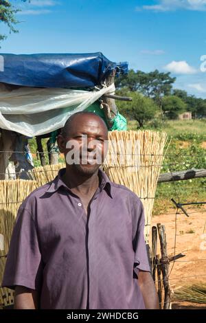 african village, street vendor, old entrepreneur man selling brooms ,small business Stock Photo