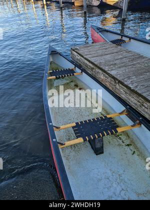 View of an empty boat on the jetty in the foreground at the end of the season in the fall Stock Photo