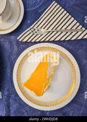 Close-up of a slice of apricot cake on a blue festive tablecloth Stock Photo
