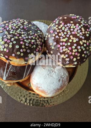 Pancakes with chocolate icing and sprinkles and with powdered sugar known as doughnuts for carnival Stock Photo