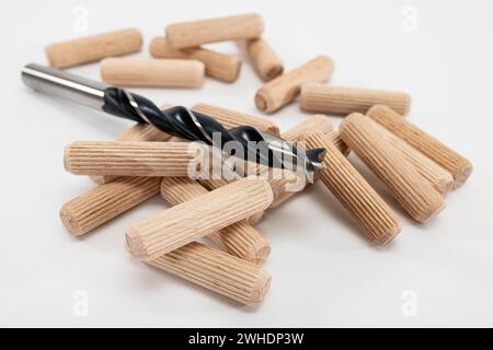 10 mm wood twist drill lies on several 10 mm wooden dowels, white background, Stock Photo