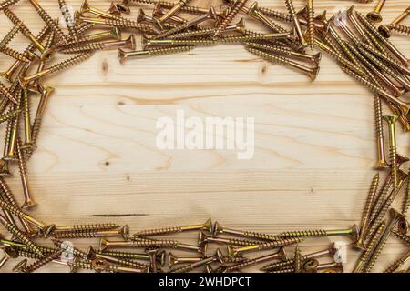 Many Torx chipboard screws with countersunk head, yellow galvanized, text free space, wood background, Stock Photo
