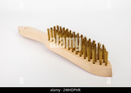 Hand wire brush with wooden handle, brass brush, blur, white background, Stock Photo