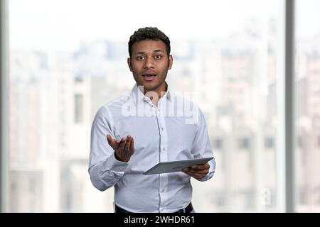 Young Indian business speaker using digital tablet. Manager presenting new project at office. Stock Photo