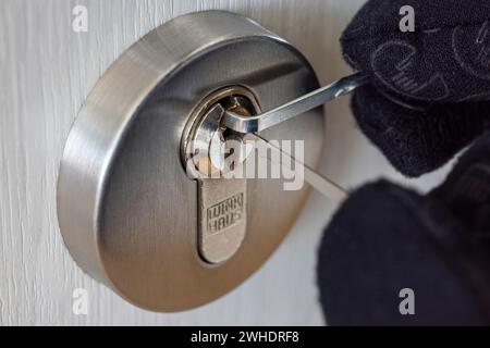 Burglar opens cylinder lock with lockpicking tool, man's hand with glove, detail, symbolic image, burglary, Stock Photo