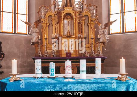 Baptismal candles lined up on altar in Catholic church Stock Photo