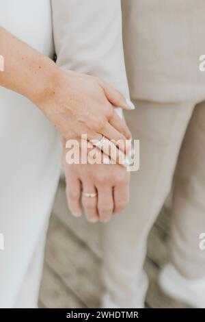 Couple holding hands, close-up, detail, focus on rings Stock Photo