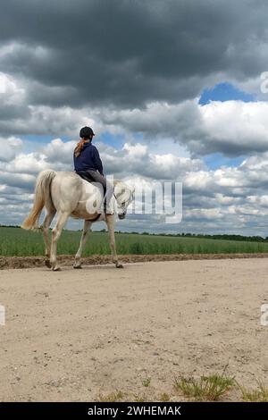 "19.05.2023, Germany, Brandenburg, Bruchmuehle - Young woman on a horseback ride. 00S230519D169CAROEX.JPG [MODEL RELEASE: YES, PROPERTY RELEASE: NO (c Stock Photo