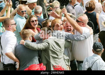 '03.09.2023, Germany, Baden-Wuerttemberg, Iffezheim - People cheering at a horse race after winning a bet. 00S230903D418CAROEX.JPG [MODEL RELEASE: NO, Stock Photo