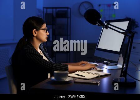 Tired businesswoman working at night in office Stock Photo
