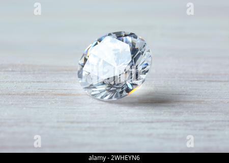 Beautiful shiny diamond on light wooden table Stock Photo