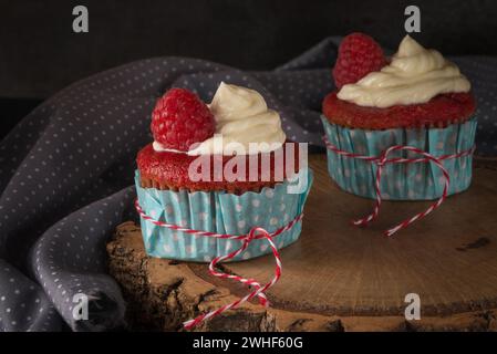 Red cupcakes with cream cheese frosting Stock Photo