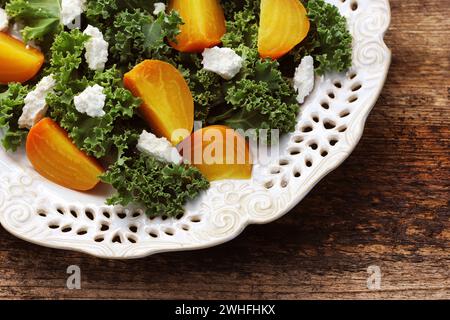 Golden beet salad with fresh kale lettuce, feta cheese on wooden background Stock Photo