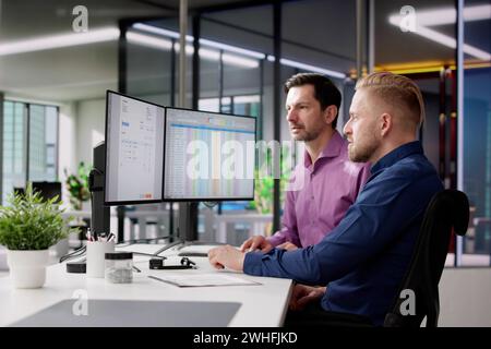 Accountants Looking At Invoice Spreadsheet On Computer Monitor Stock Photo