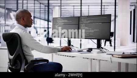 African American Coder Using Computer At Desk. Web Developer Stock Photo