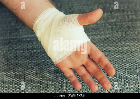 Injured painful hand with white gauze bandage Stock Photo